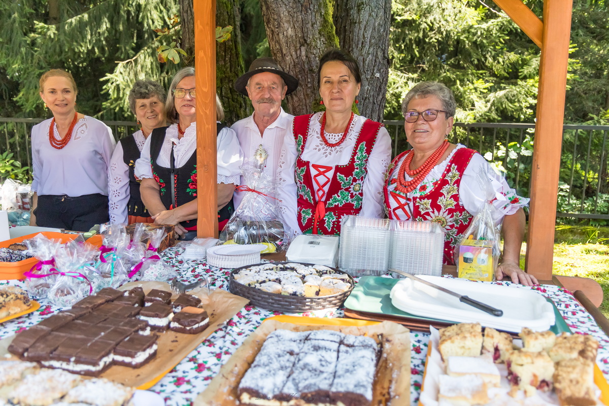 Panie w góralskich strojach na stoisku z ciastami.