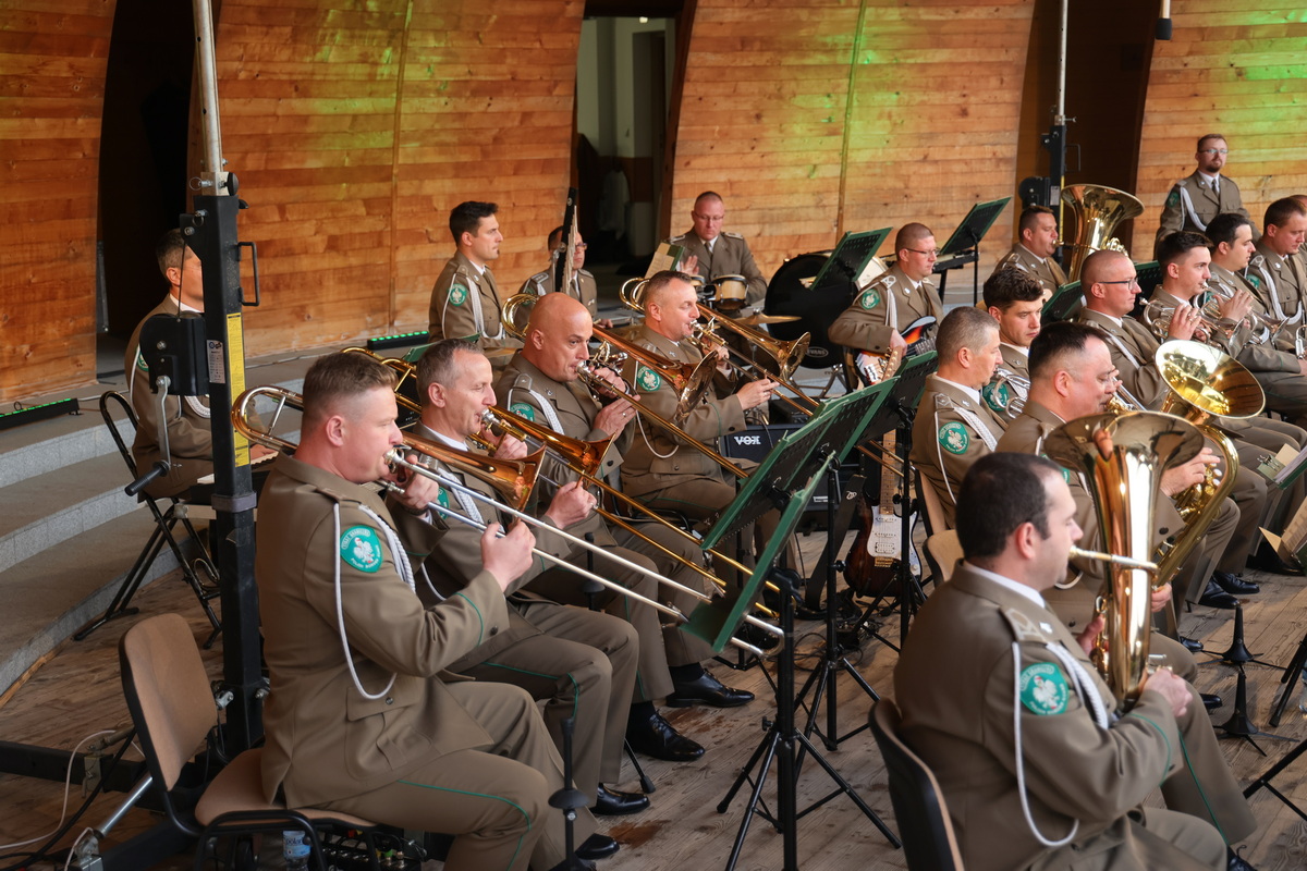 Muzycy na scenie grają na instrumentach dętych.