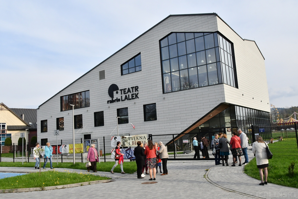 Przed budynkiem teatru gromadzą się widzowie.