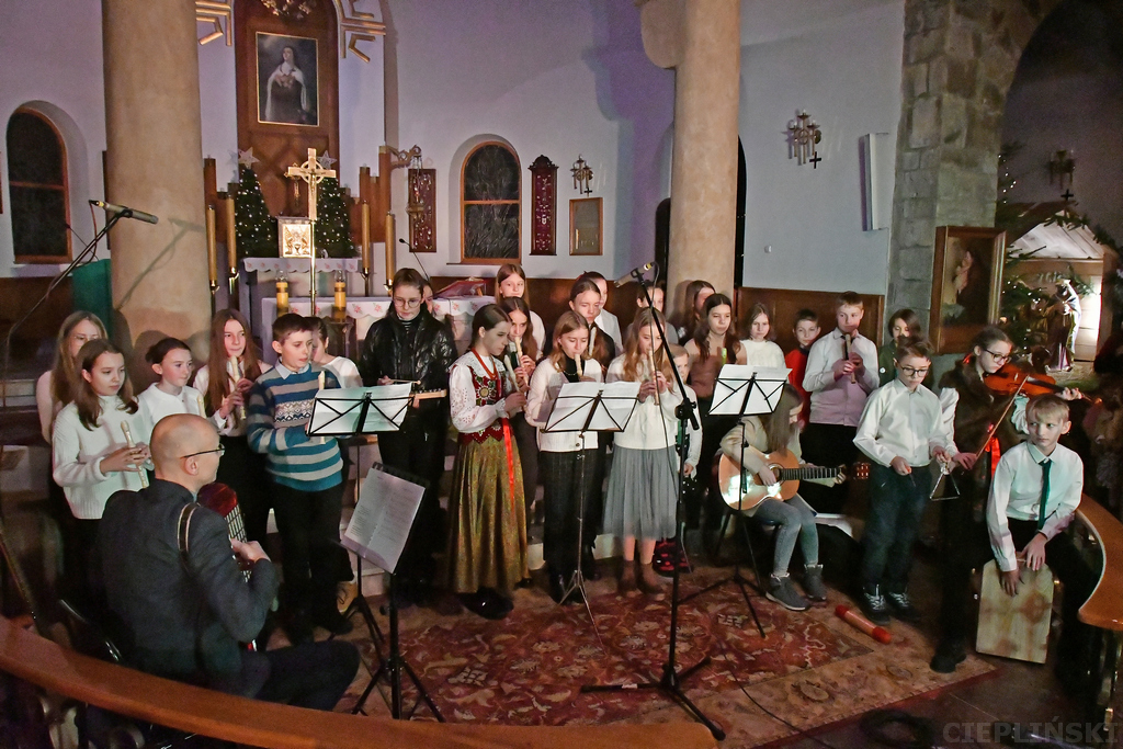 Zespół dzieci grających między innymi na fletach prostych, gitarze i skrzypcach.