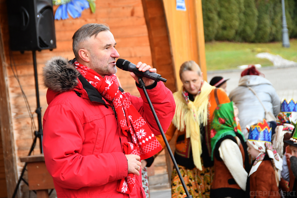 Mężczyzna mówi przez mikrofon do uczestników orszaku.